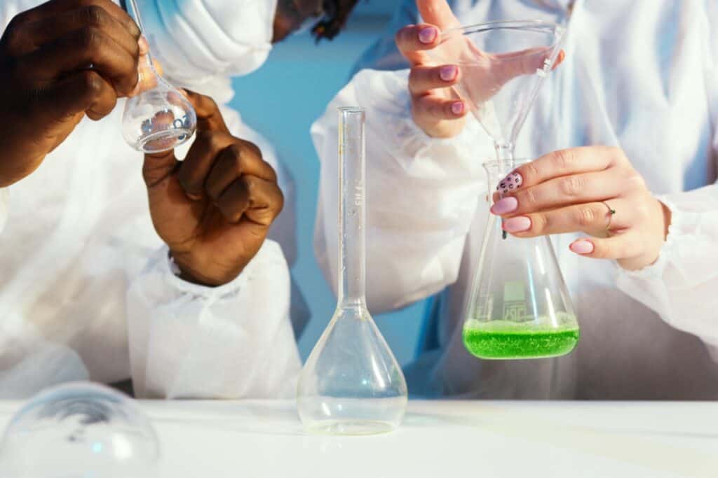 Cropped image of students working on an experiment in the chemistry lab