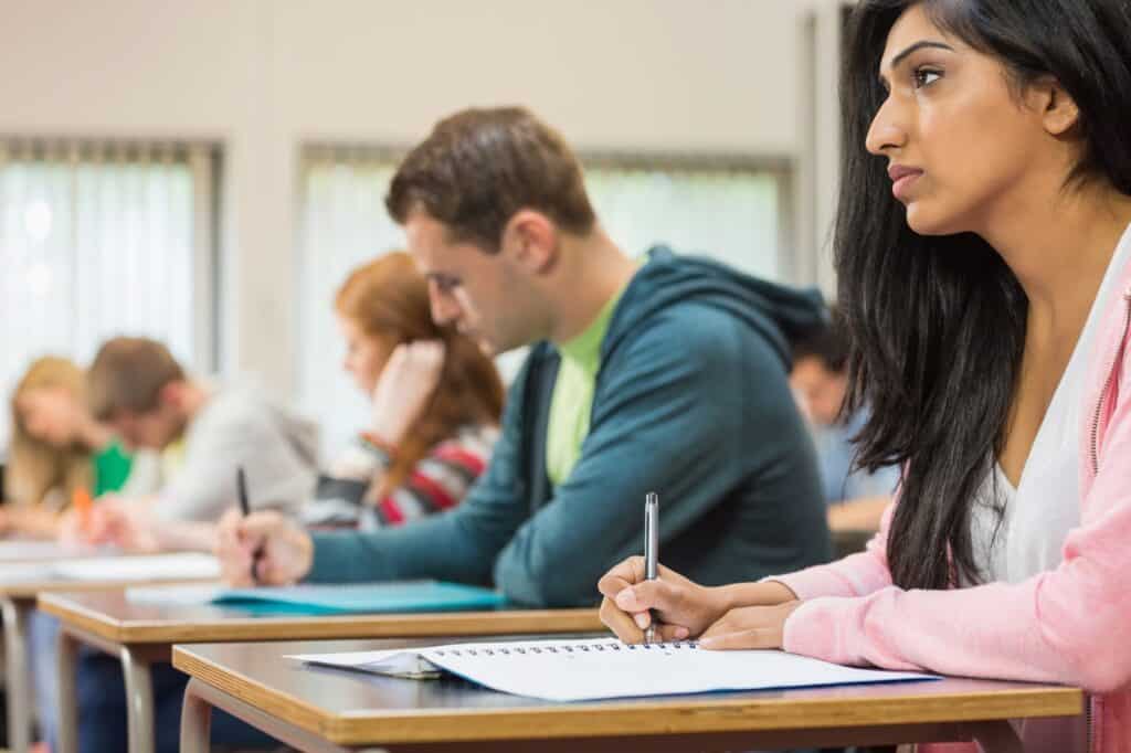 Side view of students taking notes during the class in the concept of 'top schools in Finchley'.