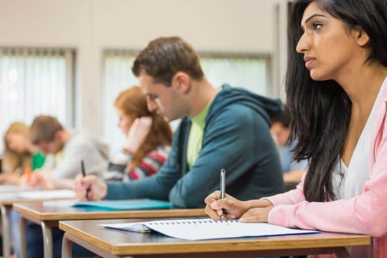 Side view of students taking notes during the class in the concept of 'top schools in Finchley'.